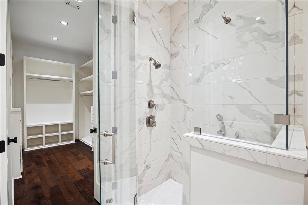 Wood floors even extend into the primary suite walk-in closet giving a clean and elegant look.