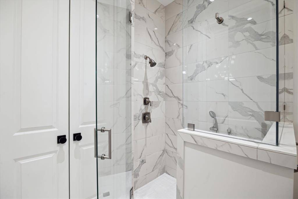 The primary en suite walk-in shower is a quiet escape from the day’s troubles.