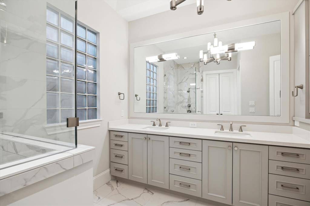 Abundant cabinets and large mirrors in the primary en suite bathroom are welcome features.