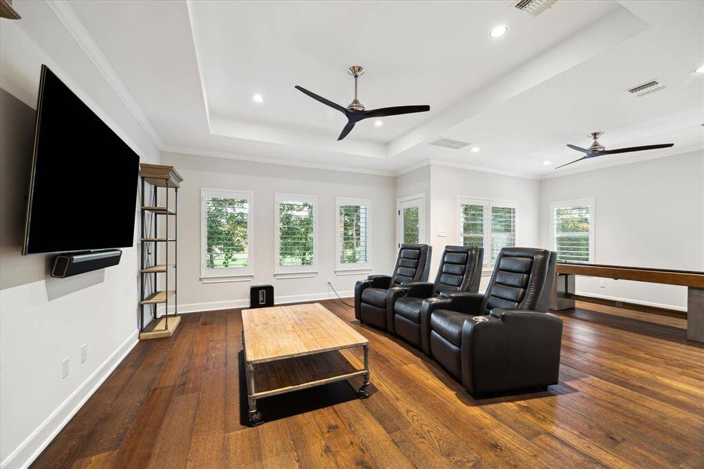 A bonus family room with coffered ceiling,a fan and lots of large windows creates another wonderful space to relax or entertain.