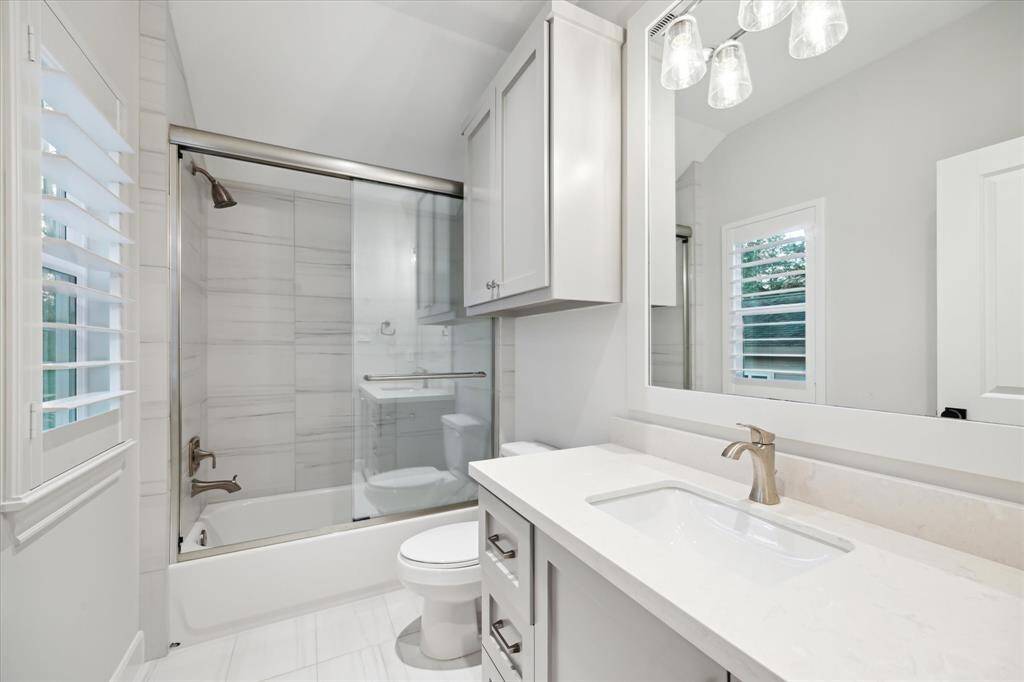 Guests staying in the home can indulge in a spa-like experience within this beautifully appointed bathroom. A sleek glass shower door adds an elegant touch, while the inviting bathtub offers the perfect escape for a soothing soak after a long day. Thoughtfully designed with comfort and relaxation in mind, this serene space ensures a rejuvenating retreat, allowing visitors to unwind in style. With refined finishes and a tranquil ambiance, it’s a haven of relaxation that elevates the guest experience.