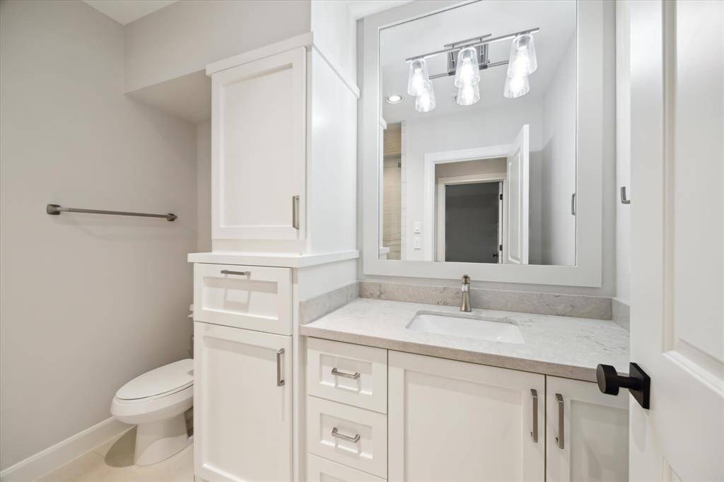 White cabinets and custom lights create a fresh clean space in this guest bathroom.