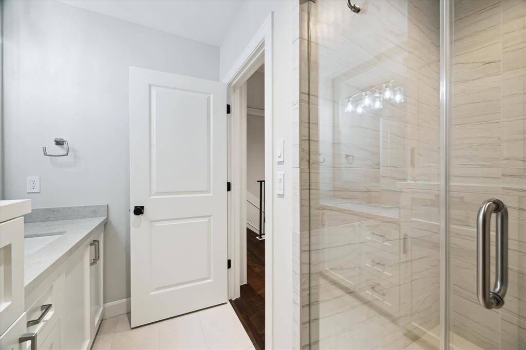 This stand-up shower with floor to ceiling backsplash is both elegant and coveted.