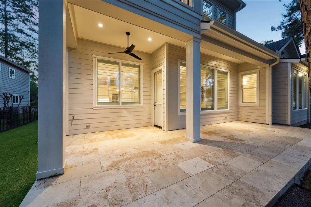 A covered tile porch with ceiling fan has space for an outdoor grill and your favorite patio furniture.