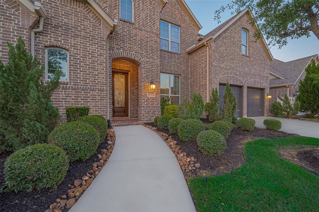From the moment you arrive, you’ll be captivated by the home’s stunning curb appeal, featuring a beautifully landscaped yard and an inviting walkway that leads to a striking wood and glass front door, setting the tone for the elegance that continues throughout the interior.