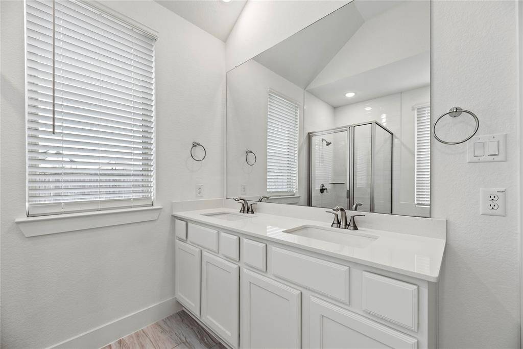 The primary bath offers dual vanities with plenty of storage.
