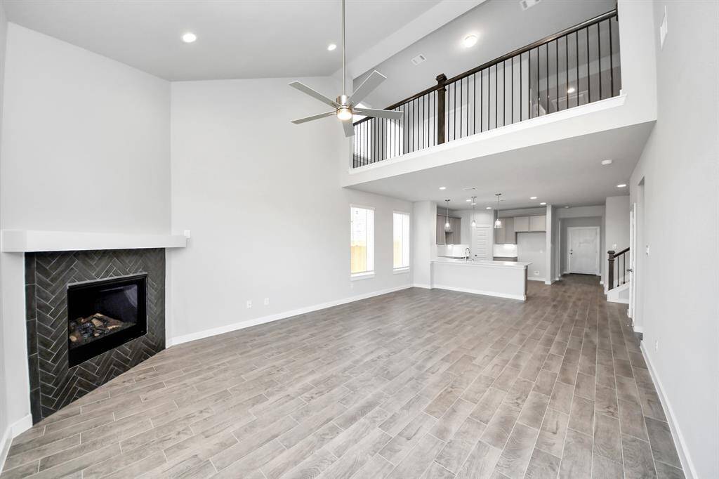 Gather the family and guests together in your lovely living room! Featuring soaring high ceilings, recessed lighting, ceiling fan, custom paint, gorgeous floors, and large windows that provide plenty of natural lighting throughout the day. Sample photo of completed home with similar floor plan. Actual colors and selections may vary.