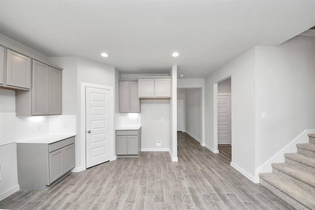 This kitchen is by far any chef’s dream! This spacious kitchen features high ceilings, light stained wood cabinets, granite countertop, SS appliances, modern tile backsplash, recessed lighting, and extended counter space. Sample photo of completed home with similar floor plan. Actual colors and selections may vary.