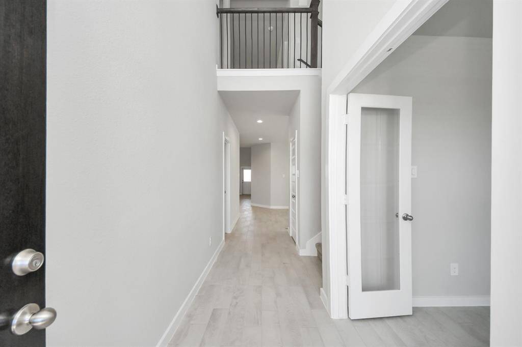 Indulge in luxury as you step into the threshold of this breathtaking home. The grand entrance beckons with its soaring ceilings, adorned with elegant wood-look tile flooring featuring sleek oversized baseboards. Cast your gaze upwards to a mesmerizing view of the open staircase. Follow the path of natural light streaming through expansive windows as you make your way to the family room, creating an inviting and warm atmosphere. Sample photo of completed home with similar floor plan. Actual colors and selec