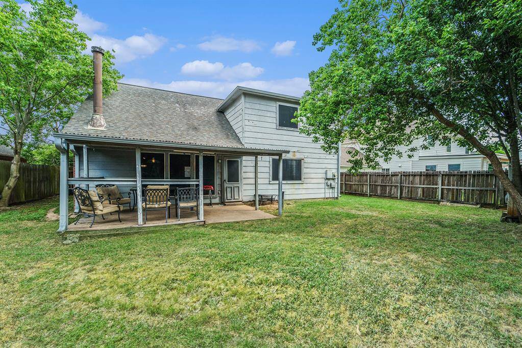 The backyard features a covered patio, a storage shed, and lots of green space.