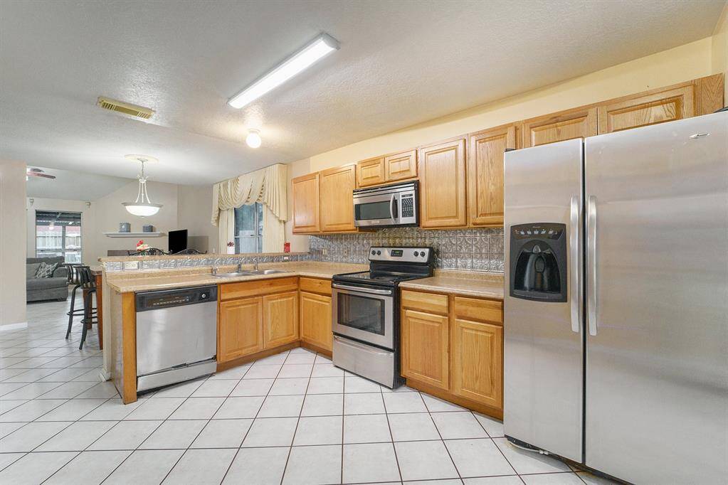 This amazing kitchen features tons of cabinet and countertop space, a breakfast nook, and is open to the living room.