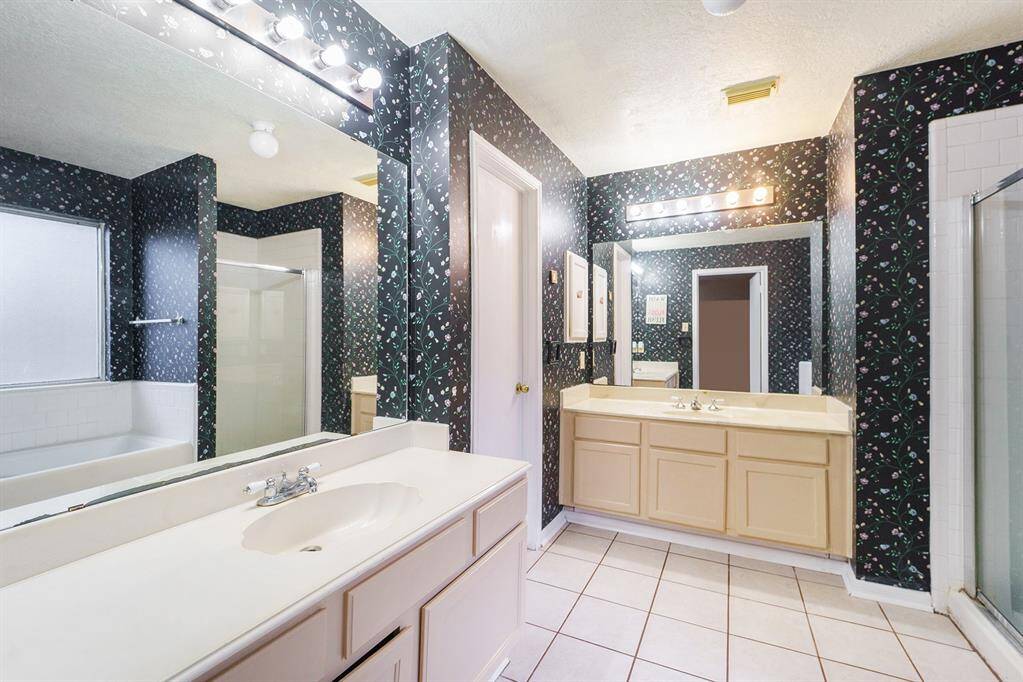 Primary en suite offers dual vanitites, a soaking tub, and a glass-standing shower.