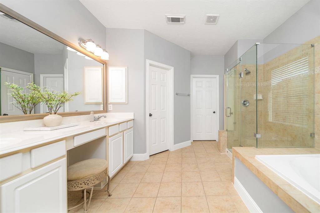 Primary bathroom with two vanities, soaking tub, and standing shower!