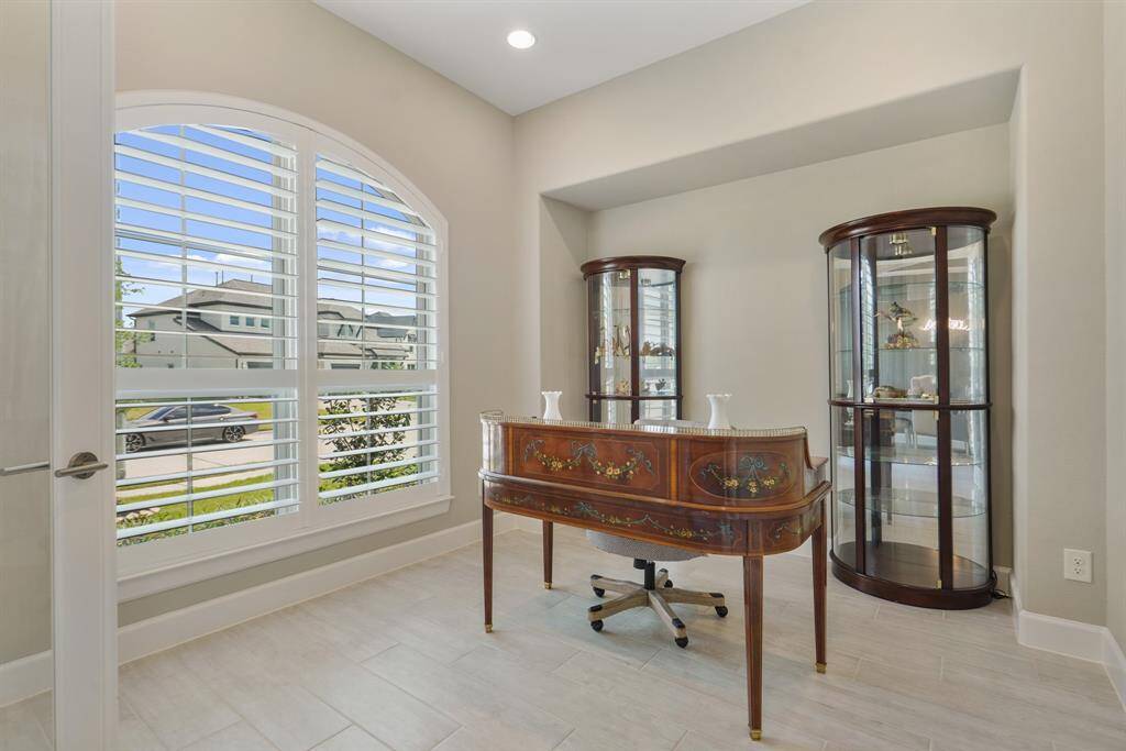 Located at the front of the home, this flex room is filled with natural light provided by large windows accented by wooden shutters, stunning glass paneled doors, and a perfectly sized alcove.
