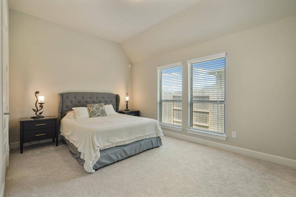 This spacious secondary bedroom features an en-suite bath with walk-in closet, plush carpet and twin windows for gentle natural light.
