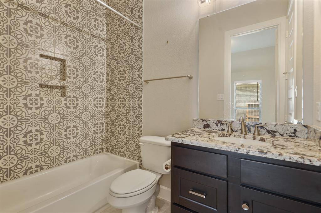 Each secondary bathroom features high-end granite countertops and a stylish patterned tile surround.