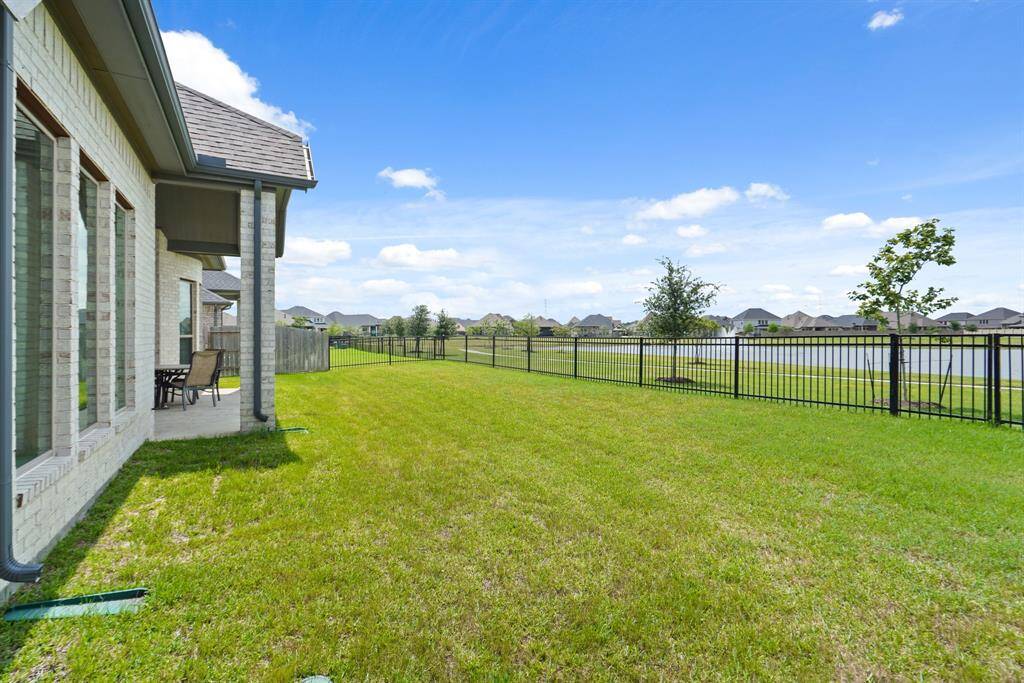 The fully fenced backyard offers plenty of lawn for pets, play, or even future pool plans, and is easily maintained with a sprinkler system.