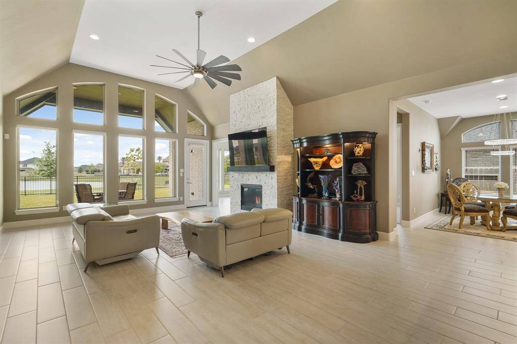 The living room is filled with natural light, which flows effortlessly into the kitchen, breakfast area, and a hallway for a harmonious, functional layout.