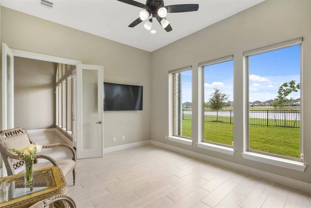 One of the two flex rooms, wrapped in tall windows, perfect for morning coffee or quiet reading, while enjoying your beautiful view.