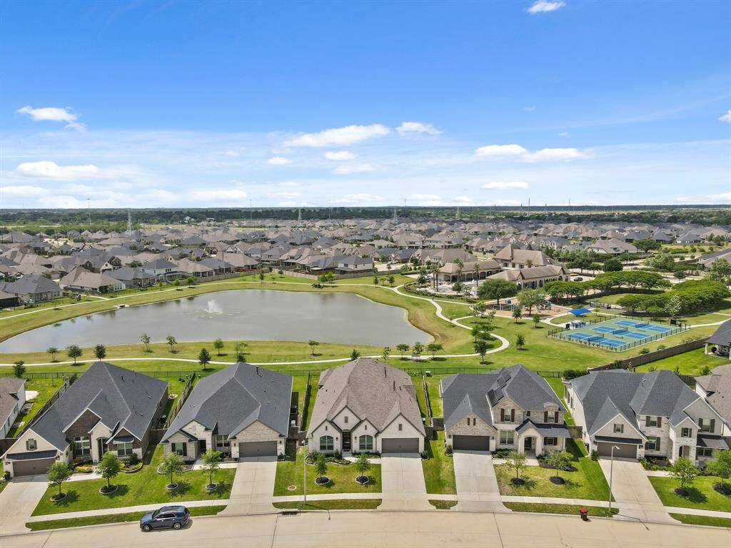 Aerial view showcasing the home’s location within the Amira neighborhood, featuring its close proximity to the amenity center and serene views of the nearby pond.