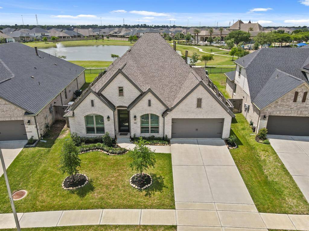 Another bird’s-eye view showing the lakeside path, and spacious driveway that leads to the 3 car garage.