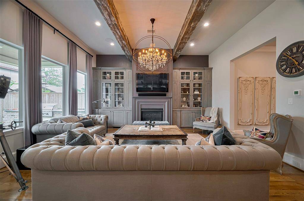 1906 Althea Dr. Designed for both comfort and style, this living room features soaring ceilings and rich architectural details that make a lasting impression. A sleek gas fireplace anchors the space, complemented by custom built-ins that offer elegance and functionality. Natural light pours in through oversized windows, highlighting the refined finishes and inviting atmosphere. It’s the perfect setting for relaxed evenings or upscale entertaining.