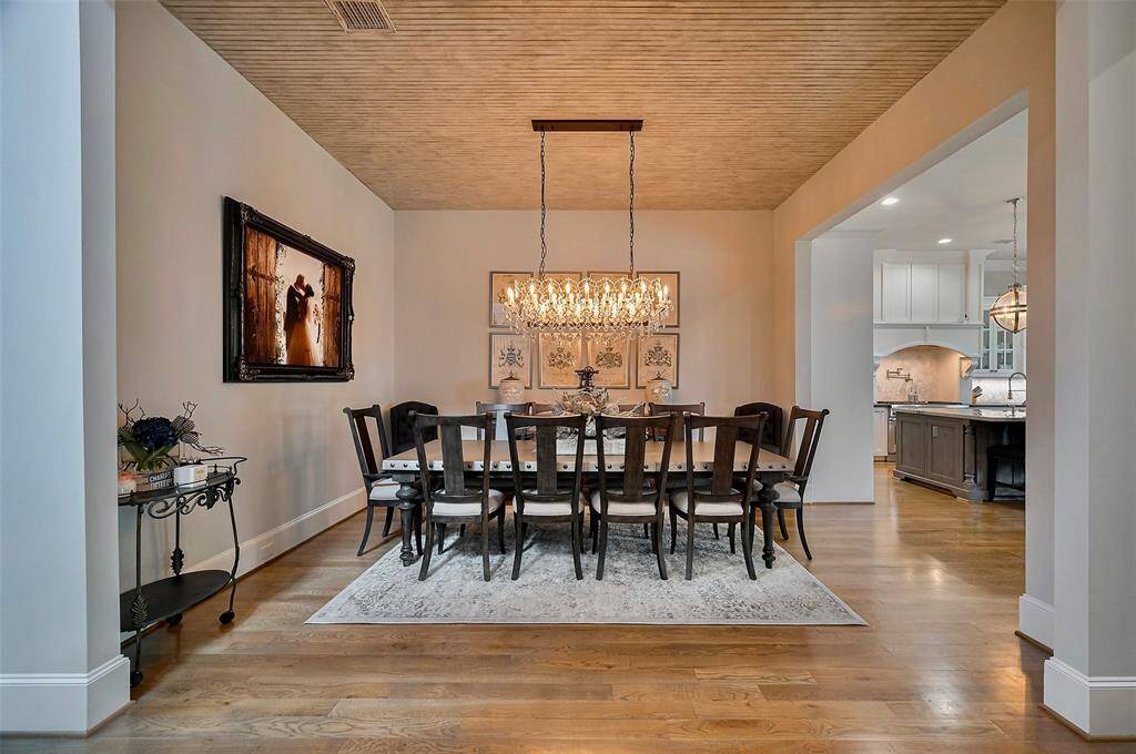 This formal dining room exudes timeless elegance and understated luxury. A custom shiplap panel ceiling adds architectural interest and texture, drawing the eye upward and creating a sense of intimate sophistication.