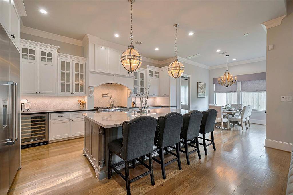 From the chef’s kitchen, take in the refined elegance of the surrounding space, where custom millwork and extra-wide crown molding elevate every detail. The kitchen itself is a culinary dream, outfitted with professional-grade appliances and designed for both beauty and performance.
