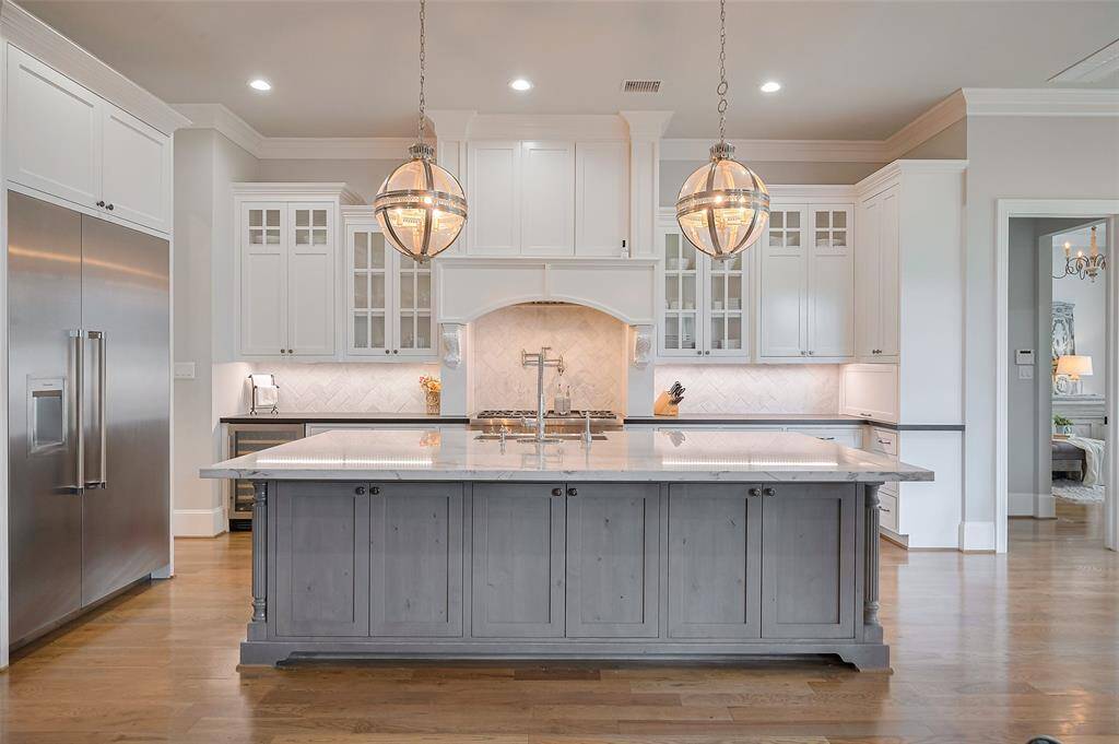 Custom cabinetry with glass-front display doors offers timeless charm, while soft-close drawers and doors throughout ensure a quiet, seamless experience. Every detail has been thoughtfully selected to create a space that’s as beautiful as it is functional—tailored for both everyday living and exceptional entertaining.