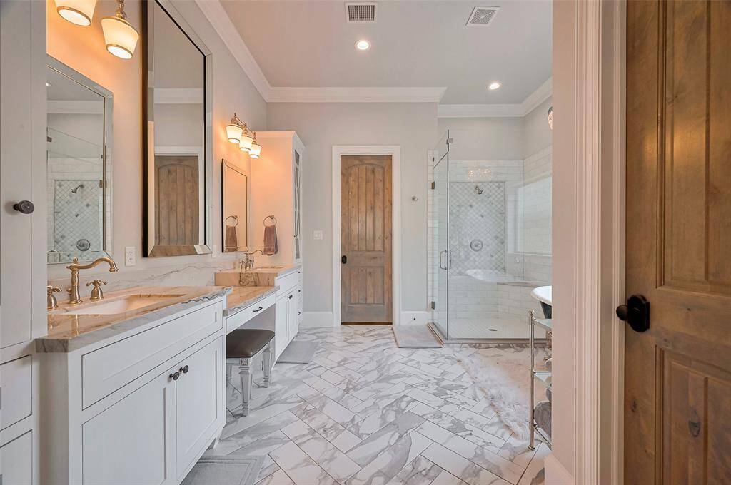 This spa-like bathroom offers a serene escape, featuring elegant herringbone tile, abundant storage, and thoughtful design throughout. Every detail creates a calming, functional space that feels both luxurious and effortless.