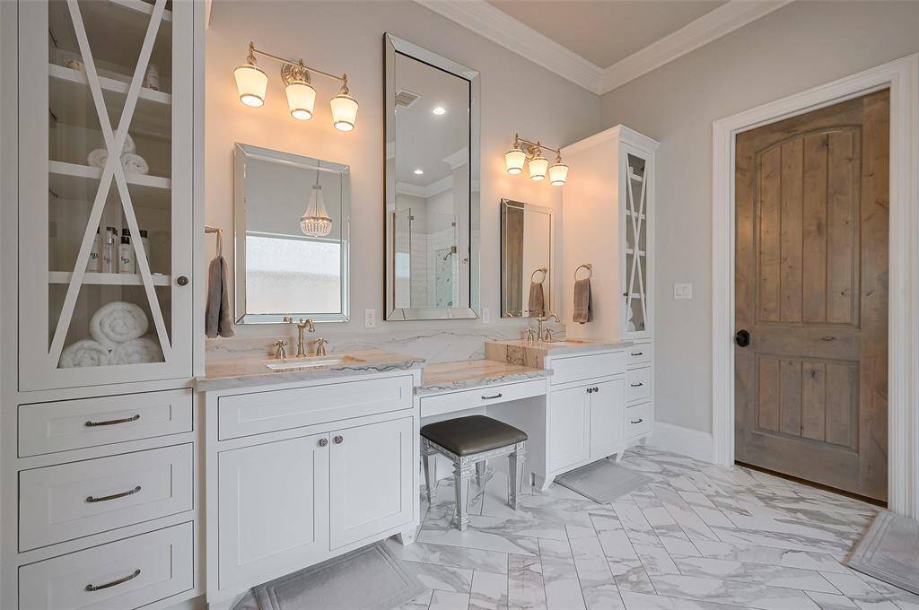 The elegant vanity features double sinks and is accented by polished nickel light and plumbing fixtures, adding a refined, timeless touch. Thoughtfully designed with both beauty and function in mind, this space is the perfect blend of classic luxury and everyday convenie