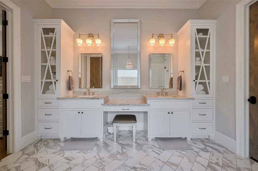 The primary bath impresses with tall ceilings and an airy, spa-like ambiance. Custom glass-front doors with an elegant X-design add a bespoke touch, while soft-close drawers and cabinetry offer quiet luxury and everyday convenience. A perfect blend of style, storage, and serenity.