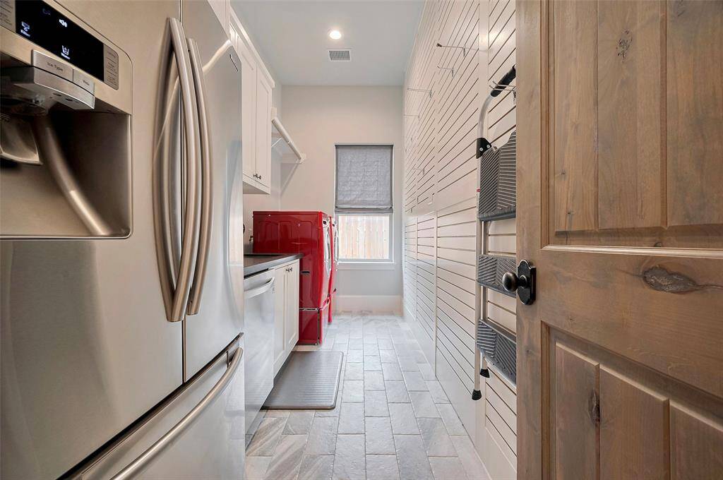 The mudroom, conveniently located just off the garage, combines function and charm with custom cabinetry, reclaimed wood paneling, and ample storage throughout. Thoughtful touches like bench, hanging hooks and built-in shoe storage at the base make this space perfect for keeping everyday essentials organized and out of sight.