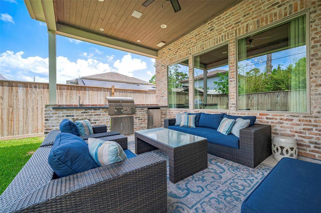 Step out to the covered patio, designed for year-round enjoyment with a wood plank ceiling, recessed lighting, and a ceiling fan for added comfort. The outdoor kitchen makes entertaining a breeze, blending style and functionality in this inviting outdoor retreat.