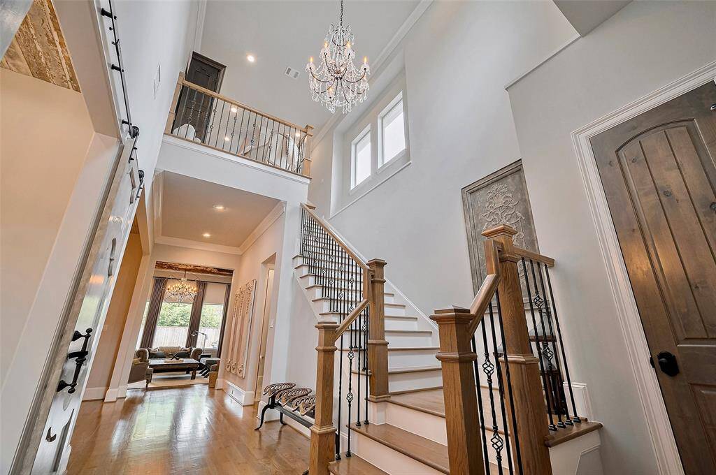Step into a breathtaking two-story foyer bathed in natural light, where soaring ceilings and a statement chandelier set an elegant tone from the moment you arrive. The space feels open and grand, yet warm and welcoming.