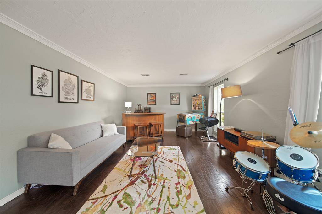 The welcoming den features wood floors, crown molding, custom paint, and large windows.
