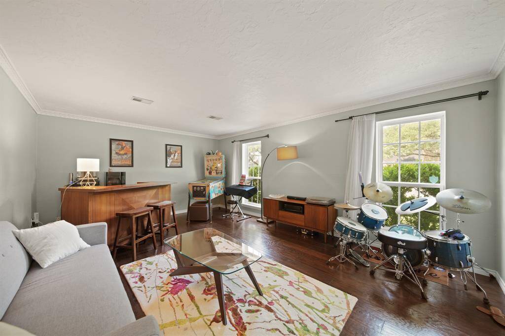 The welcoming den features wood floors, crown molding, custom paint, and large windows.
