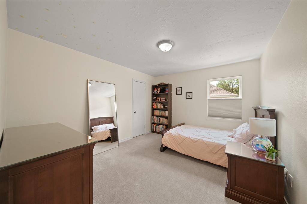 Secondary bedroom features awindow and plush carpet.