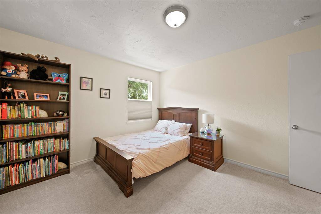 Secondary bedroom features awindow and plush carpet.