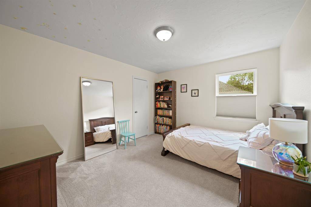 Secondary bedroom features awindow and plush carpet.