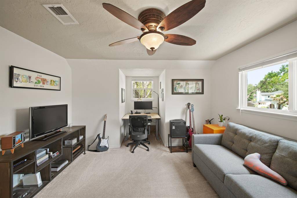 Third bedroom features large windows, ceiling fan, and plush carpet.