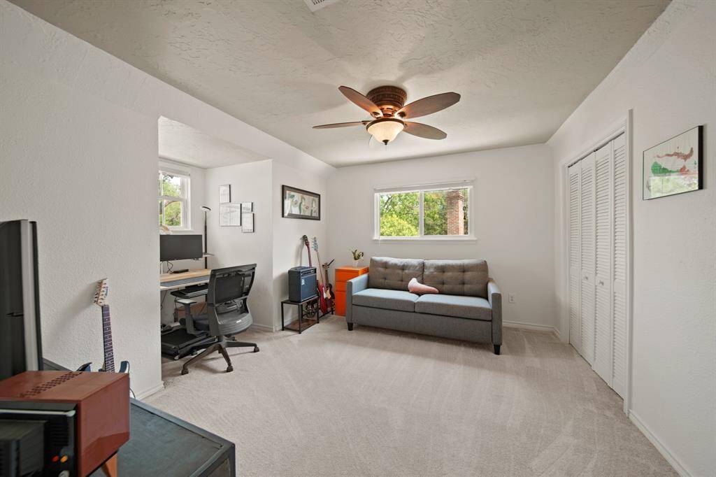 Third bedroom features large windows, ceiling fan, and plush carpet.