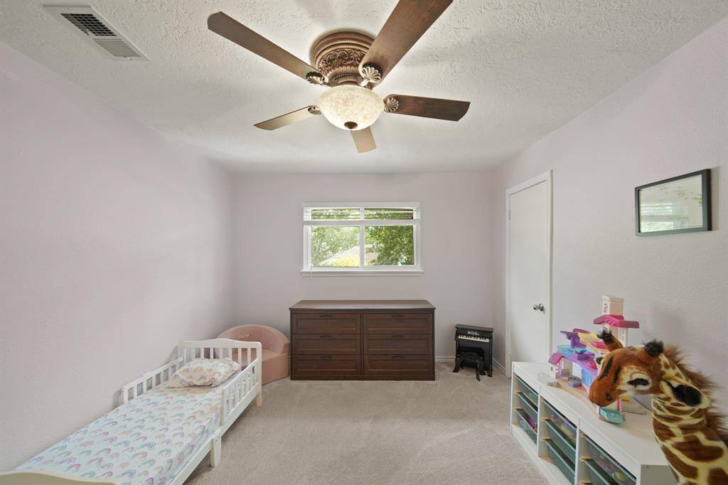 Fourth bedroom features a large window, ceiling fan, and plush carpet.