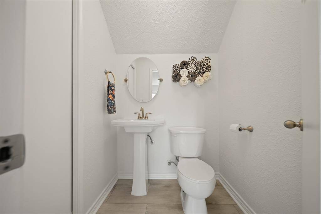 The half bathroom features a modern pedestal sink.