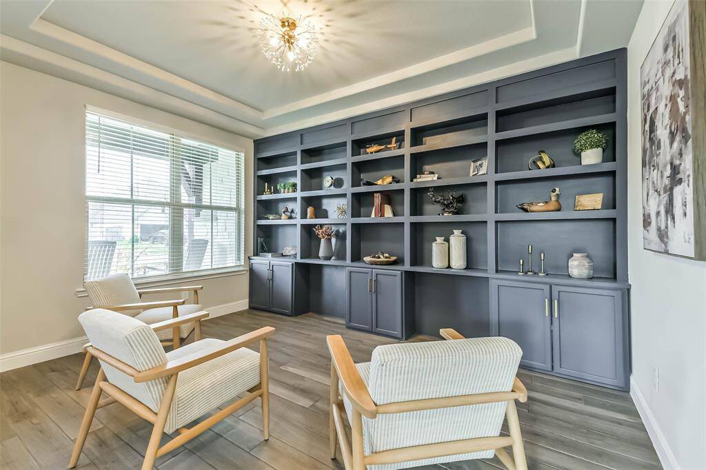 Formal dining room has custom built-ins and upgraded light fixture with trayed ceiling. Double windows look to the front porch. Use as intended or as another private sitting area.