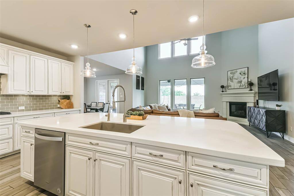 Oversized island with quartz counters and pendant lighting provides ample space for seating or serving. This space is perfect for entertaining.
