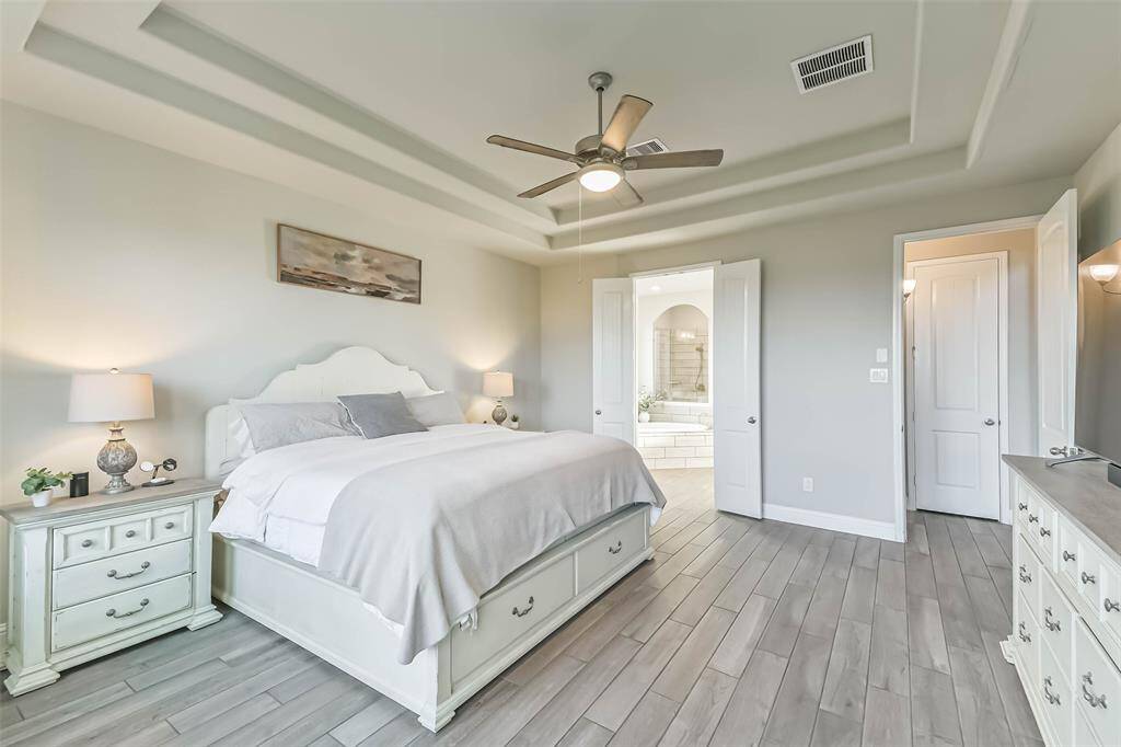 Primary bedroom opens to a spa-like primary bathroom suite.