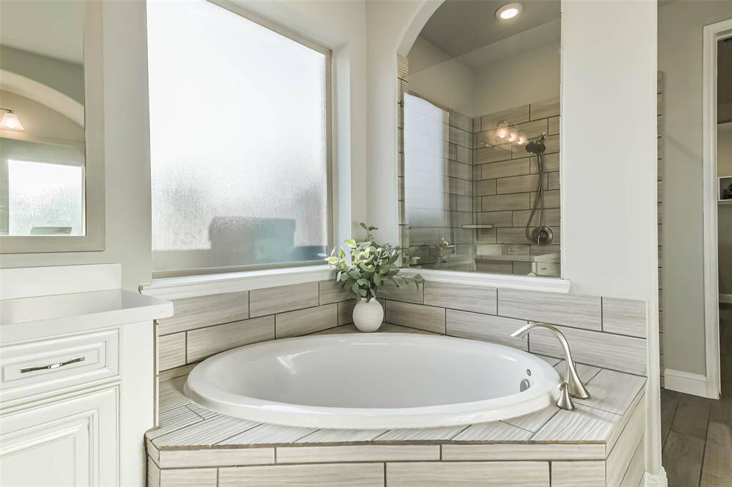 Soaking tub with airy, light shower beyond