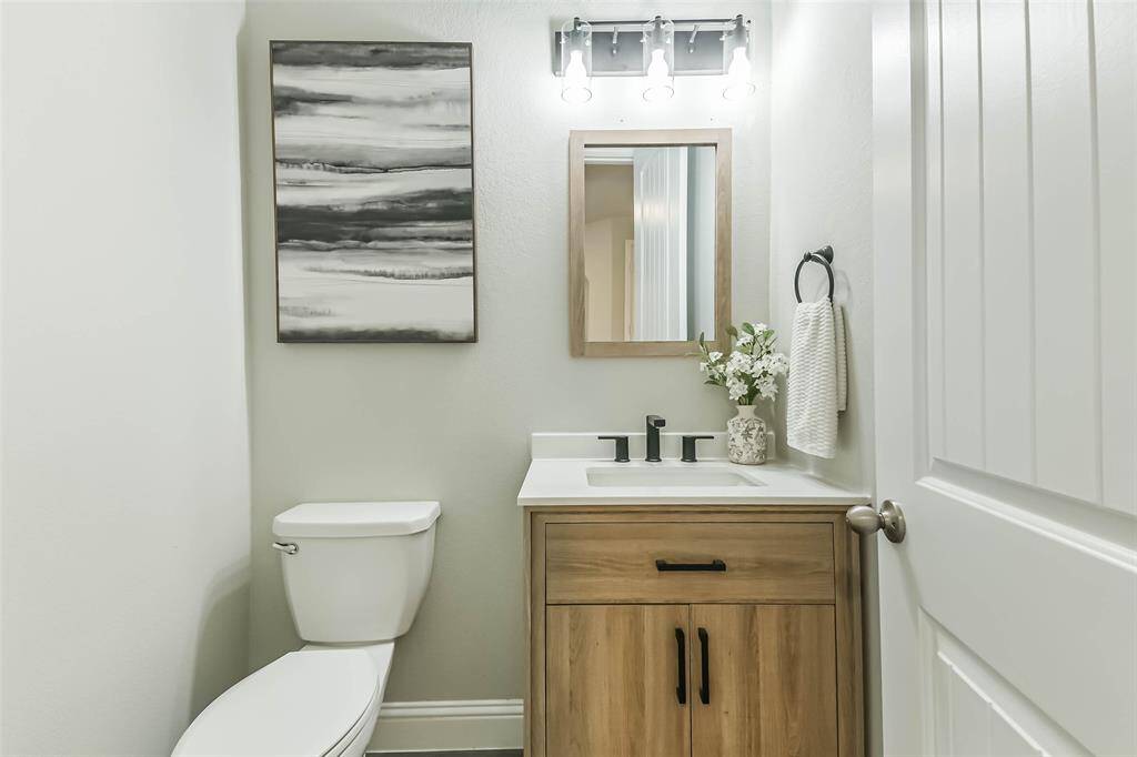 Upgraded half bath with storage opens from the entry hall.