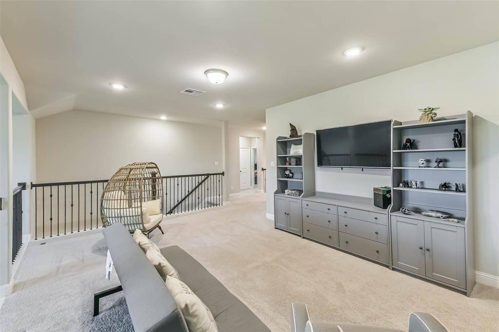 Extra lighting provides different lighting options in this oversized game room surrounded by upgraded railing with iron spindles.